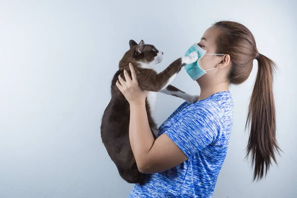 Koronavirüsü korumak için maske takan bir kız. Öğleden sonra 2,5 ve kedi kürküne alerjisi var. Coronavirus ve Hava Kirliliği Öğleden Sonra 2.5 kavramı.