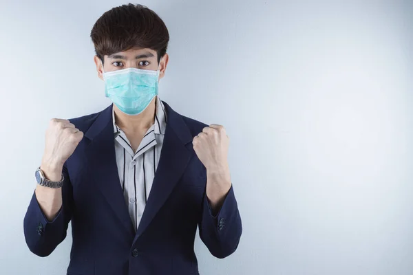 İş adamı Coronavirus 'u korumak için maske takıyor ve 2.5 saat sonra onlarla savaşmak için elini gösteriyor. Coronavirus ve Hava Kirliliği Öğleden Sonra 2.5 kavramı.