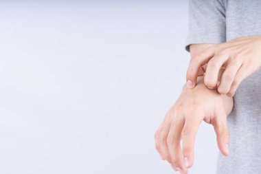 Erkek, beyaz arka planda fotokopi aletiyle elini kaşıyor. Reklam konsepti için tıbbi ve sağlık hizmeti.