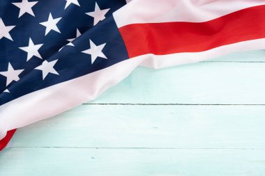 Mavi ahşap arka planda Amerikan bayrağı. ABD Anma Günü, Başkanlar Günü, Gaziler Günü, İşçi Bayramı, Bağımsızlık Günü ya da 4 Temmuz kutlamaları için. Üst görünüm, metin için boşluk kopyala.