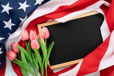 Tahtası ve mavi ahşap arka planda lale çiçeği olan Amerikan bayrağı. ABD Anma Günü, Başkanlar Günü, Gaziler Günü, İşçi Bayramı, Bağımsızlık Günü ya da 4 Temmuz kutlamaları için. Üst görünüm, metin için boşluk kopyala.