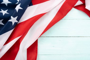 Mavi ahşap arka planda Amerikan bayrağı. ABD Anma Günü, Başkanlar Günü, Gaziler Günü, İşçi Bayramı, Bağımsızlık Günü ya da 4 Temmuz kutlamaları için. Üst görünüm, metin için boşluk kopyala.