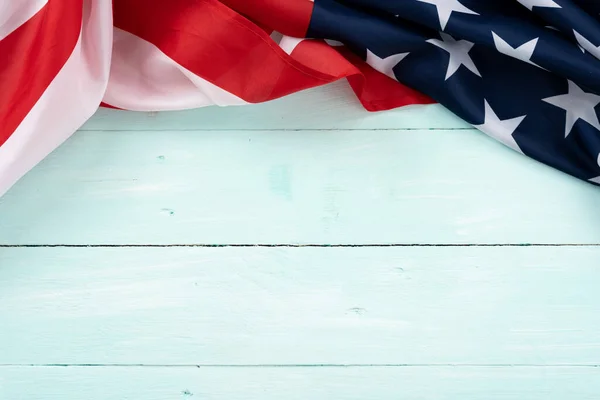 Mavi ahşap arka planda Amerikan bayrağı. ABD Anma Günü, Başkanlar Günü, Gaziler Günü, İşçi Bayramı, Bağımsızlık Günü ya da 4 Temmuz kutlamaları için. Üst görünüm, metin için boşluk kopyala.