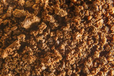 Kabaca öğütülmüş kahve çekirdekleri, bir demet fasulye. Esmer kahve dokusu, arka plan..