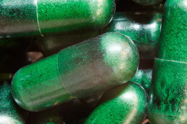 Green medical pills close up. Medications help a person defeat the virus.