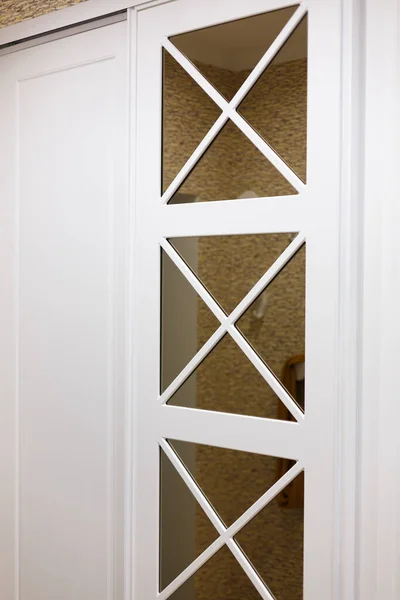 Built-in closet in the hallway, door ornament, square shapes.
