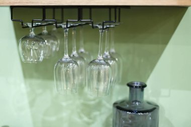 Yeşil arka planda birkaç bardak baş aşağı asılı duruyor..