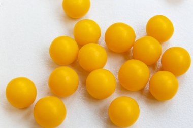 Yuvarlak sarı vitaminler, haplar, beyaz arka planda. - Yakın çekim. Hastalıklara karşı savaş. İnsan sağlığı. İlaç endüstrisi..