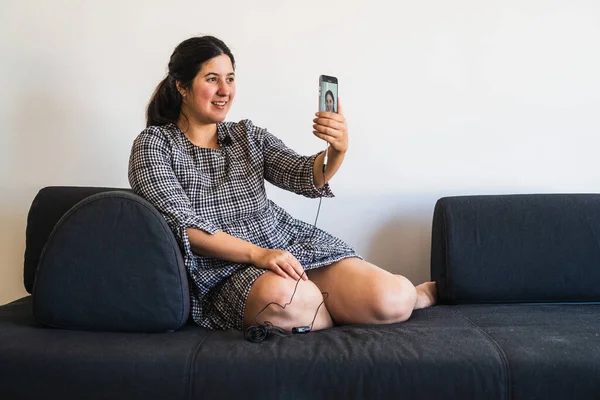 New normal situation: a girl streams live video with her smartphone on her social network profile to try adapting to this new situation where the teleworking is the best way to avoid financial crash