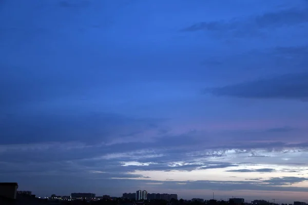 澄んだ青い空街中の夕方の空 明るい青空といくつかの雲 — ストック写真