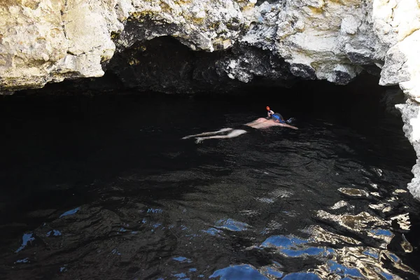 Ein maskierter Mann mit Pfeife schwimmt unter den Steinmauern der Grot — Stockfoto