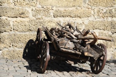 Yakacak odunları olan eski bir antika araba taşın üzerinde duruyor.