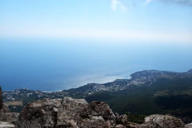 Dağın tepesinden mavi denizin kıyısında uzanan şehri ele geçirdiler. Yukarıdan temiz bir kıyı şeridi görünüyor..