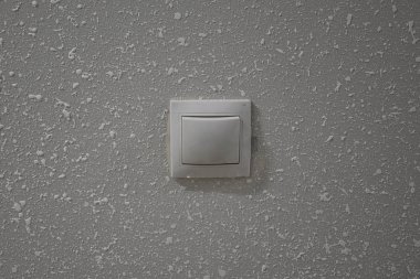 Ortasında noktalar olan beyaz bir arka planda bir ışık düğmesi var ve başka bir şey yok..