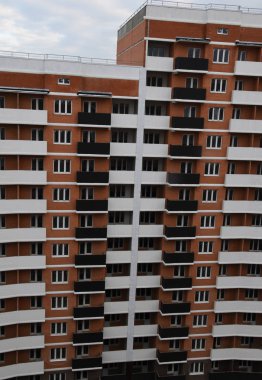 Modern bir gökdelenin ön cephesinin bir parçası. Bina kahverengi ve beyaz..