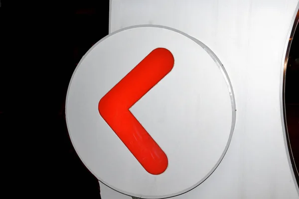 The red arrow is placed in a circle on a gray background, around night, in black.
