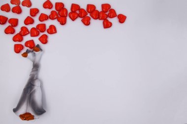 Kırmızı kalplerin arka planında gri kazların aşığı figürü. Boynu birbirine dolanmış kazların figürü, bütünlük kavramı, tüm.