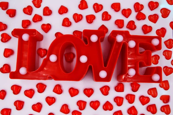 多くの小さな赤い心に囲まれた白い背景に単語の愛 バレンタインデーのためのお祭りの背景 — ストック写真