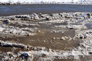 Snow melts and large, dirty puddles form. White snow still lies in some places, and in some places it has already turned into dirt.