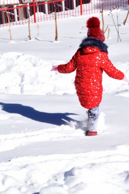 Parlak kırmızı ceketli bir kız yürür ve karın tadını çıkarır. Çocukların zevkine göre kışın çok kar vardır..