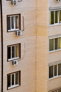 Binanın bir kısmı, tuğlaya bakan hafif tuğlalar, balkonlar ve havalandırma. Çok katlı yeni binadaki büyük pencereler.