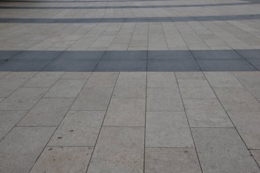 Kaya levhaları gri ve koyu gri bir şerit. Çimento arka planda, karolar meydanda.