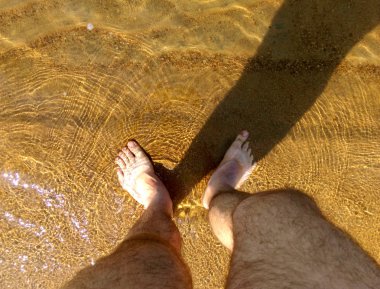 Yaz, plaj. Adam sahilde yürüyor..