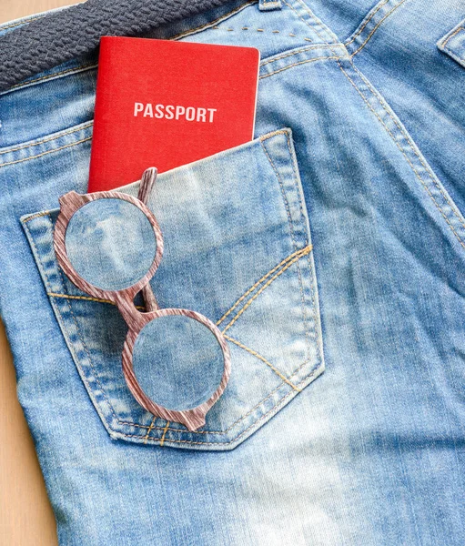 Gözlük ve kot pantolon cebinde bir pasaport — Stok fotoğraf