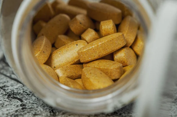 Κίτρινες αθλητικές βιταμίνες σε ανοιχτό βάζο — Φωτογραφία Αρχείου
