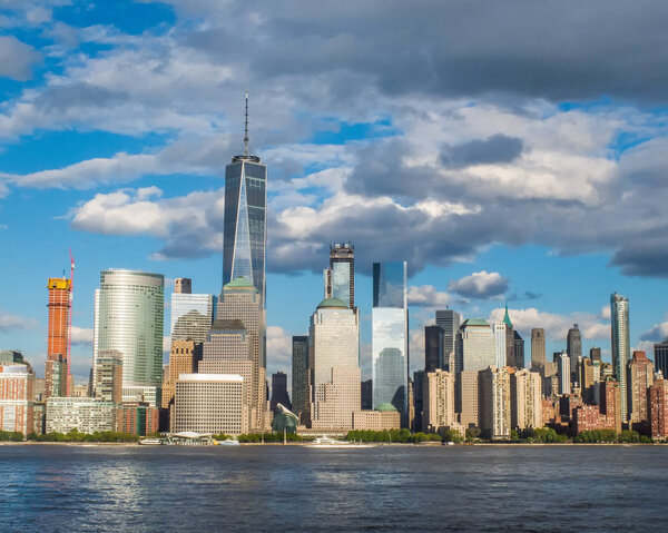 Horizontal image of the World Trade Center with the Hudson River in the foreground.