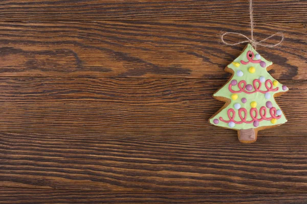 木製の背景の上にぶら下がってのジンジャーブレッドのクッキー — ストック写真