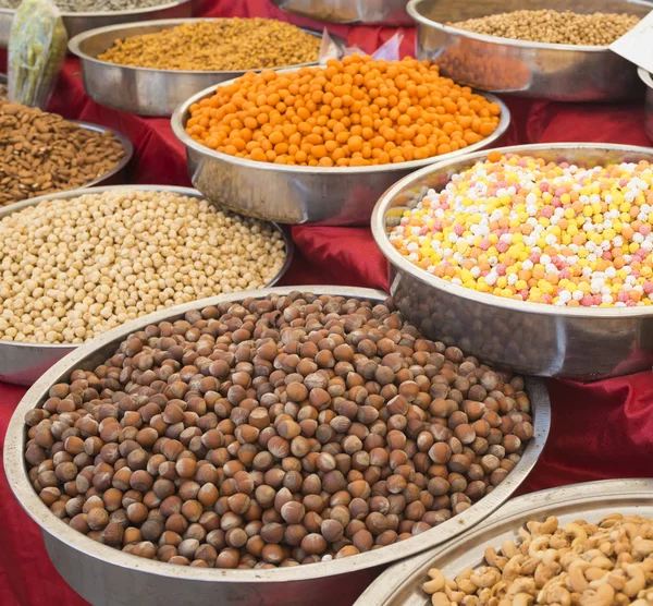 Een verscheidenheid van noten in het glazuur: pinda's, hazelnoten, kastanjes, walnoten, pistache en pecannoten. Eten en gerechten. (Selectieve aandacht) — Stockfoto