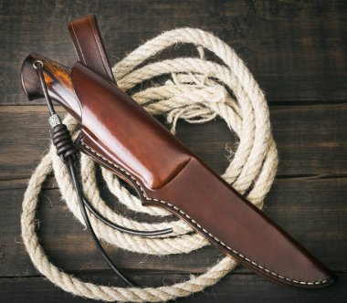 Kahverengi ahşap arka planda el yapımı avcı bıçağı.