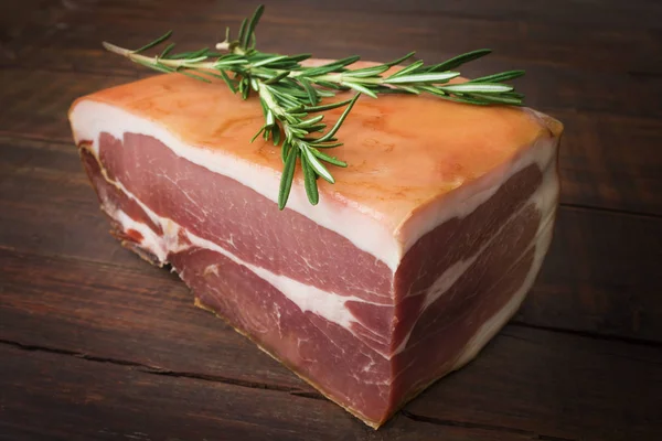 The finest prosciutto with rosemary close up on an old wooden table — Stock Photo, Image