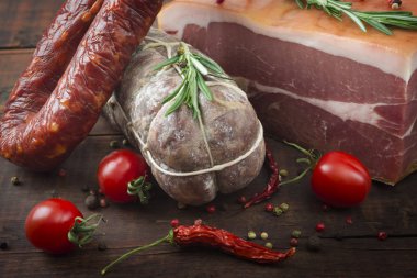 İtalyan salamı, prosciutto jambonu ve kiraz domates ve kırmızı biber ve baharat baharatlı sucuk ahşap arka plan üzerinde kapat