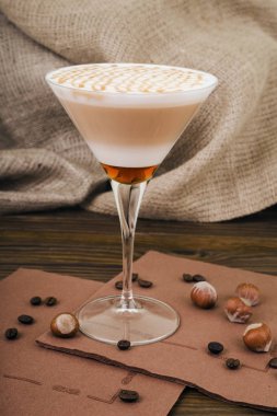 Kahve Latte. Çuval bezi ahşap bir zemin üzerine uzun bir bardak krem şanti tepesi ile kahve