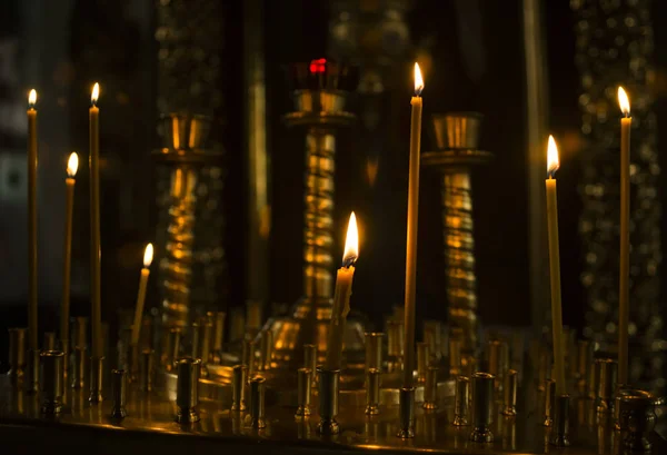 Posvátné hořící svíčky v církvi. Kostelní svíčky pozadí. Selektivní fokus — Stock fotografie