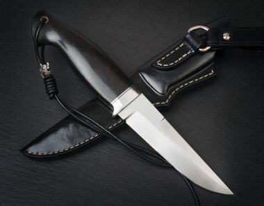 Kahverengi ahşap arka planda el yapımı avcı bıçağı.