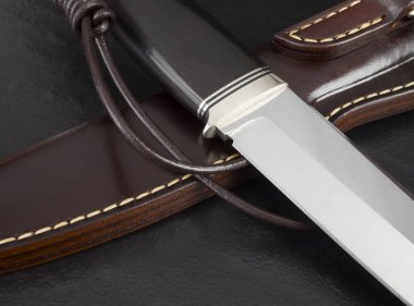 Siyah arka planda el yapımı avcı bıçağı. Deri Kaplama El Yapımı