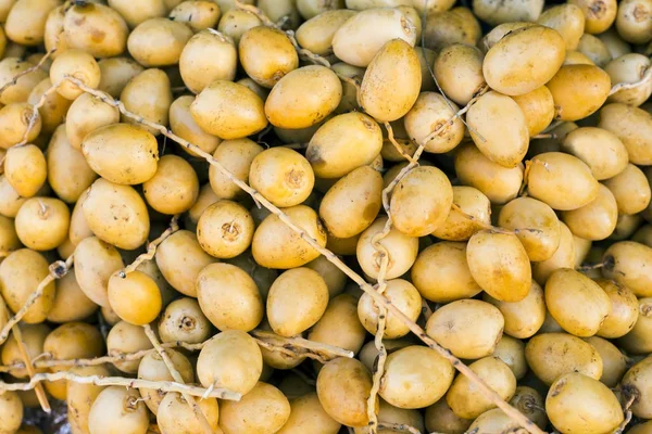 Ramas recién cosechadas con dátiles (Phoenix dactylifera) Palmera datilera en un mercado artesanal tradicional. Imagen horizontal.Alimentación saludable. Concepto de cosecha agrícola de otoño (enfoque selectivo) ) —  Fotos de Stock