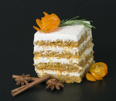 Havuçlu kek rosemary ile tarçın ve anason karanlık bir arka plan üzerinde bir delikanlı ile dekore edilmiştir. Seçici odak