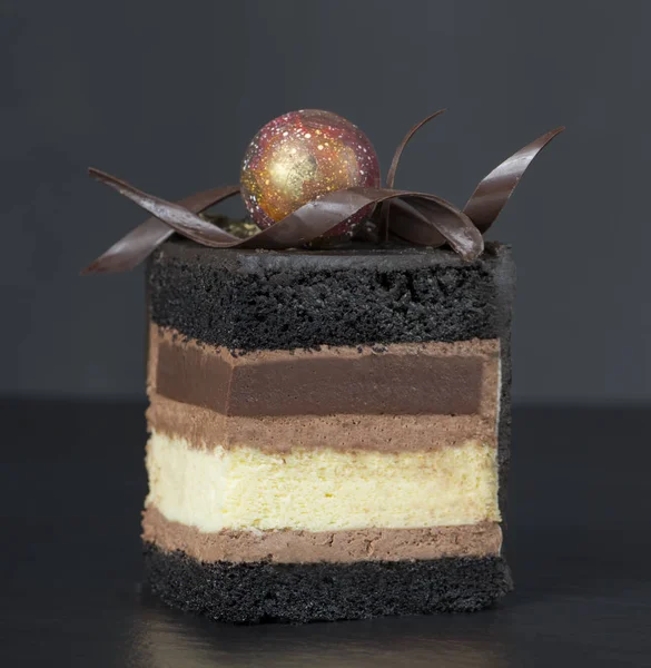 巧克力蛋糕切片与卷曲的黑暗背景特写 选择性聚焦 — 图库照片