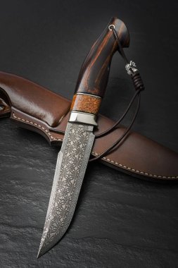 Damascus mozaik mamut dişi siyah bir arka plan ile av bıçağı. El yapımı deri kılıf