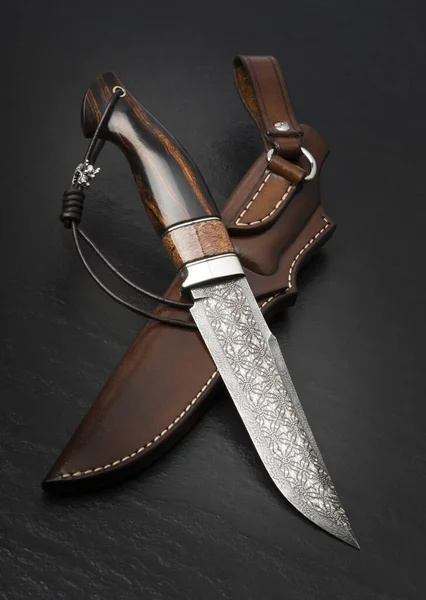 黒の背景に巨大な牙とダマスカス モザイクから狩猟用ナイフ 手作りの革製の鞘 — ストック写真