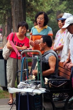 Beijing, Çin - 17 Temmuz 2011:. Kadınlar ve erkekler Jingshan Parkı'şarkı söylüyorlar. Geleneksel Sanatlar mekanlarda girişme Çinliler arasında popüler bir gelenektir