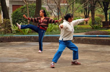 Guilin, Çin - 4 Kasım 2007: Çinli kadın parkta tai chi yapıyor. Açık havada Tai Chi, Wushu ve diğer sağlık uygulamaları - bu Çin her yaştan arasında çok popüler bir faaliyet