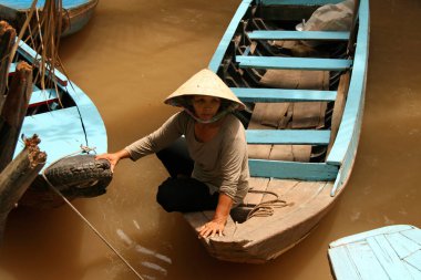 Ho Chi Minh City, Vietnam - 19 Şubat 2009: sarı sular Mekong Nehri üzerinde bir tekne yüzen Vietnamca kadın