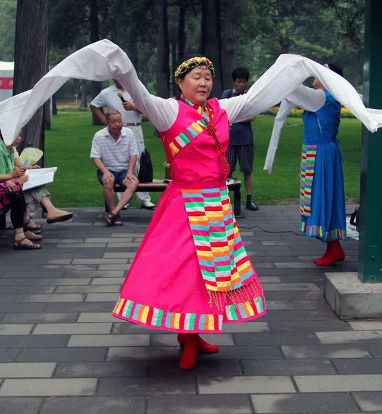 BEIJING, CHINA - 17 DE JUL DE 2011: Las mujeres bailan con disfraces nacionales en el parque Jingshan. Es una tradición popular entre los chinos para participar en las artes tradicionales al aire libre — Foto de Stock