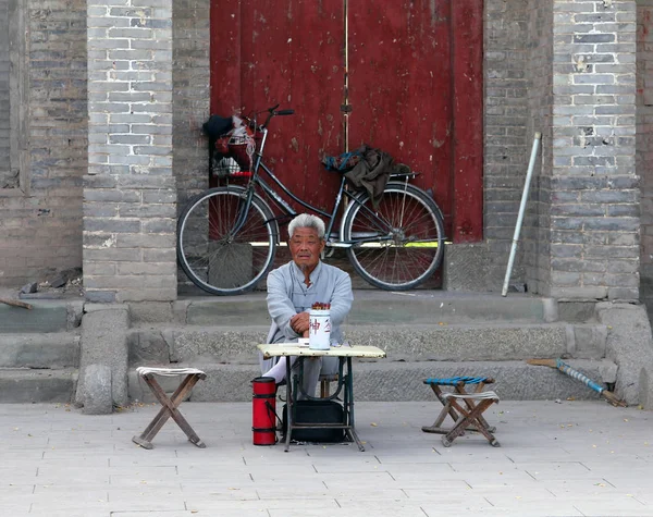 Inchuan, inre Mongoliet - 6 Jul 2011: Kinesiska fortune teller sitter vid ingången till ett buddhistiskt kloster. Gissa om bok av förändringar (I Ching) är ett av de äldsta sätten att förutsäga framtiden — Stockfoto