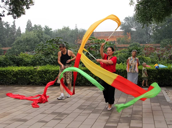 Peking, Čína - 17 Jul 2011: Čínská žena dělá gymnastiku s pásky v Jingshan park — Stock fotografie